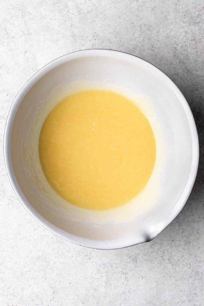 oil, eggs and sugar mixed in a white bowl