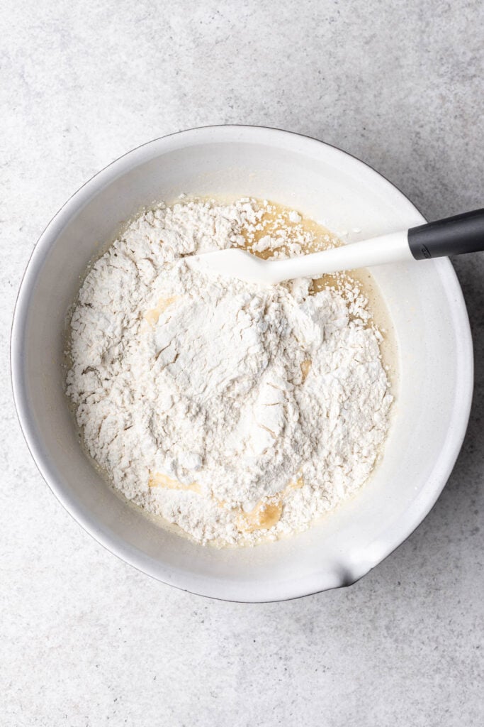 flour mixing with wet ingredients in a bowl with a whisk