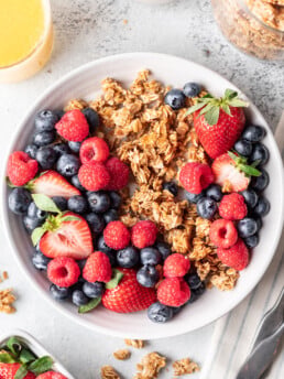 granola in a bowl with milk and berries