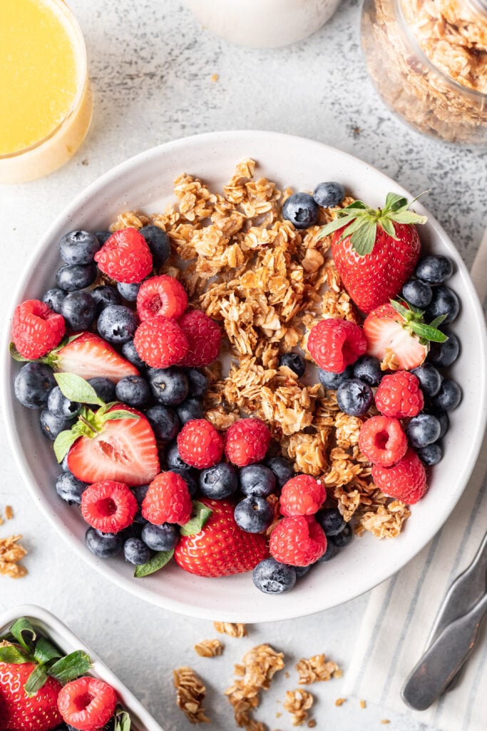 granola in a bowl with milk and berries