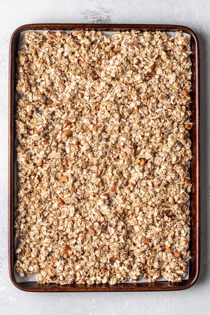 uncooked granola spread on a sheet pan