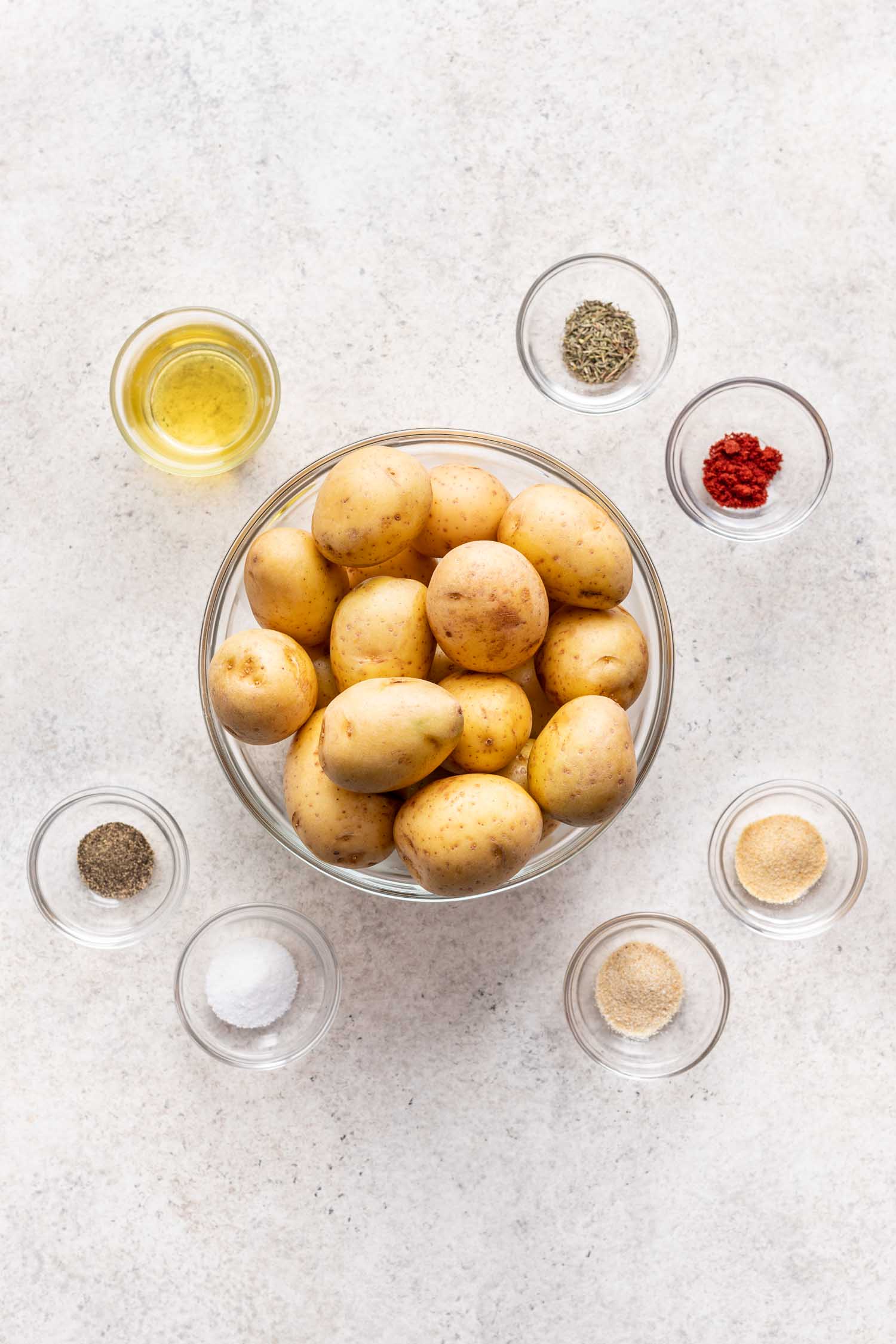 boiled potatoes in a bowl surrounded by other spice in bowls