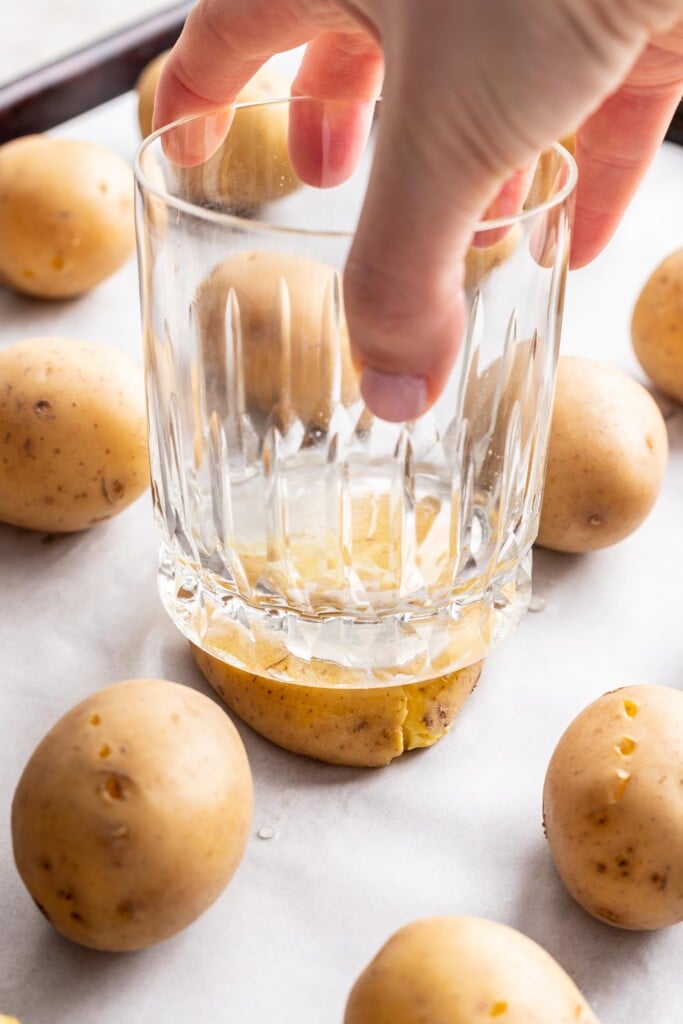 a glass smashing a baby yukon gold potato