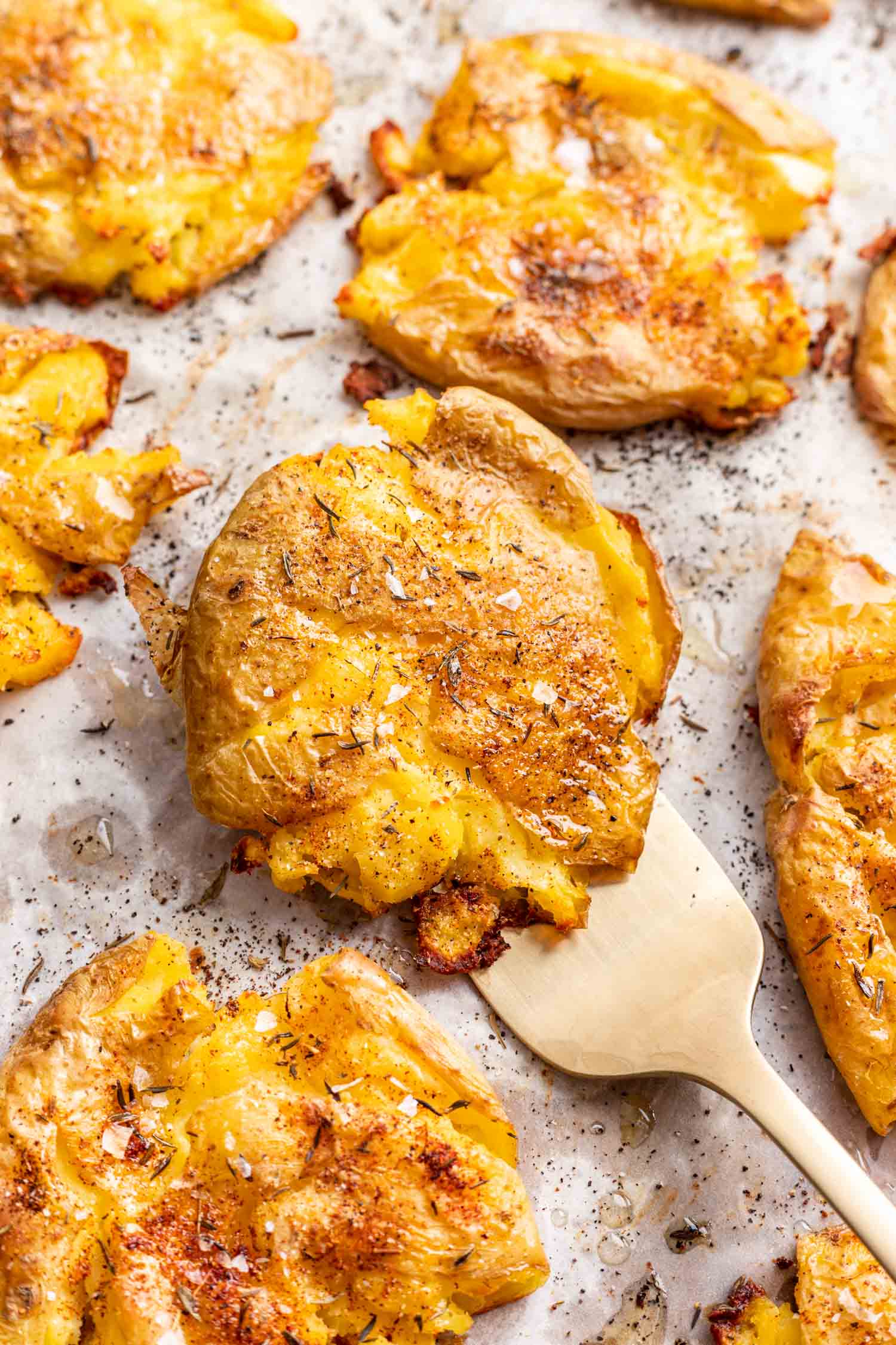 crispy smashed potato on a sheet pan with a fork