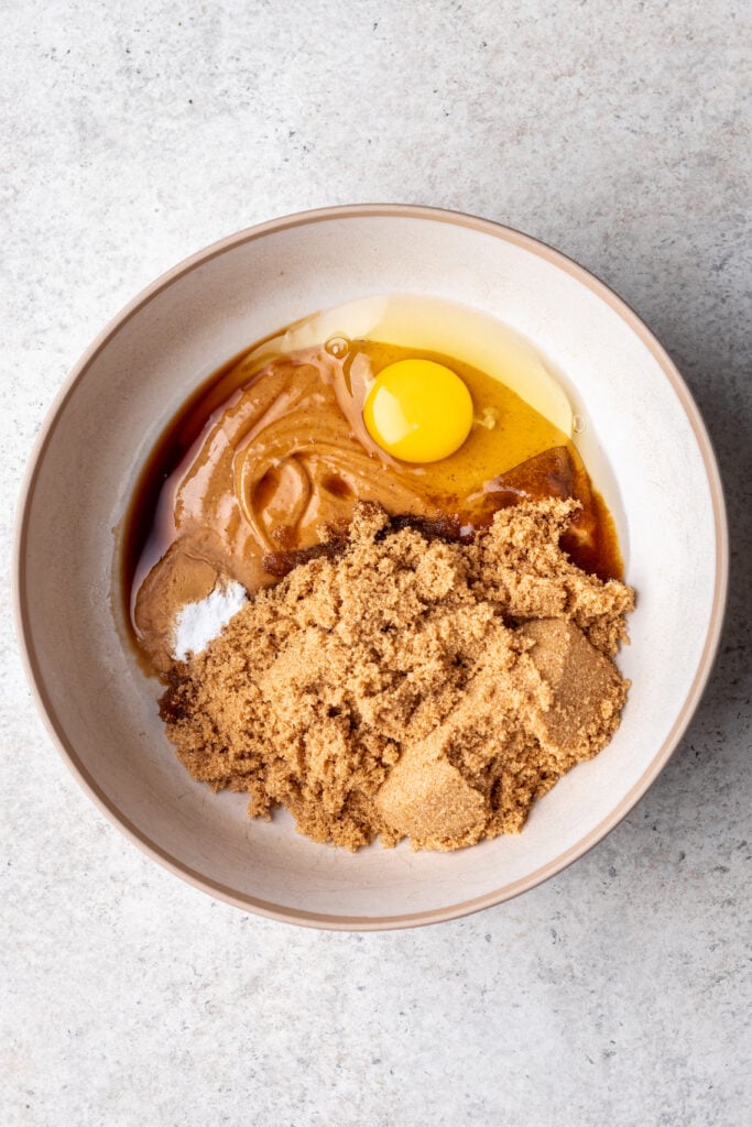 white bowl with baking ingredients like egg, sugar, peanut butter