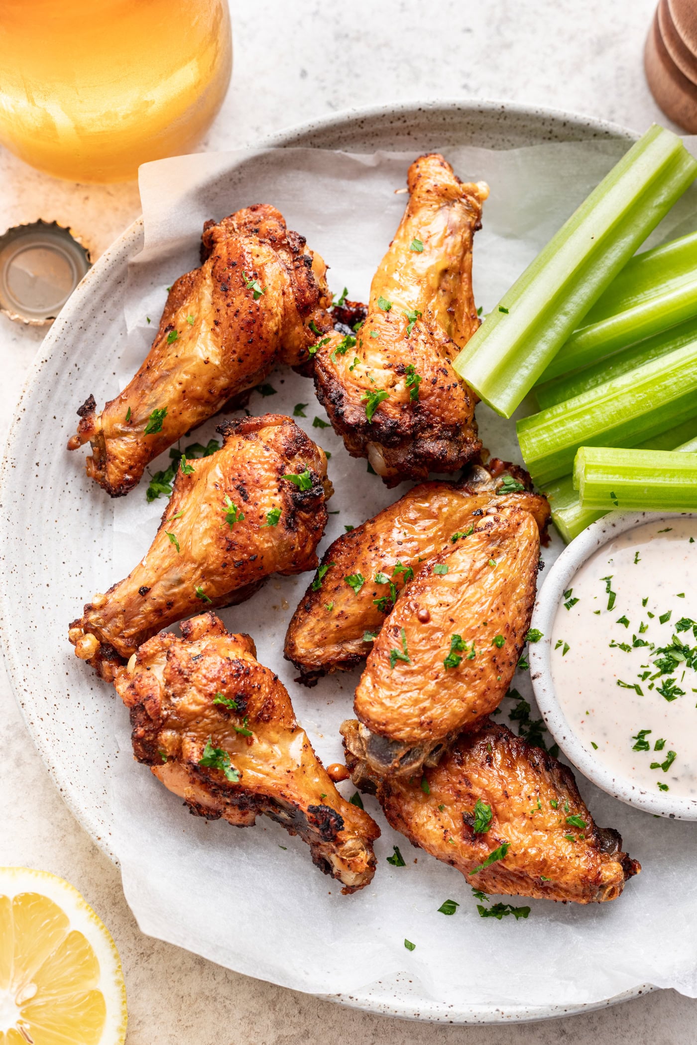 baked chicken wings on a platter with celery and dipping sauce