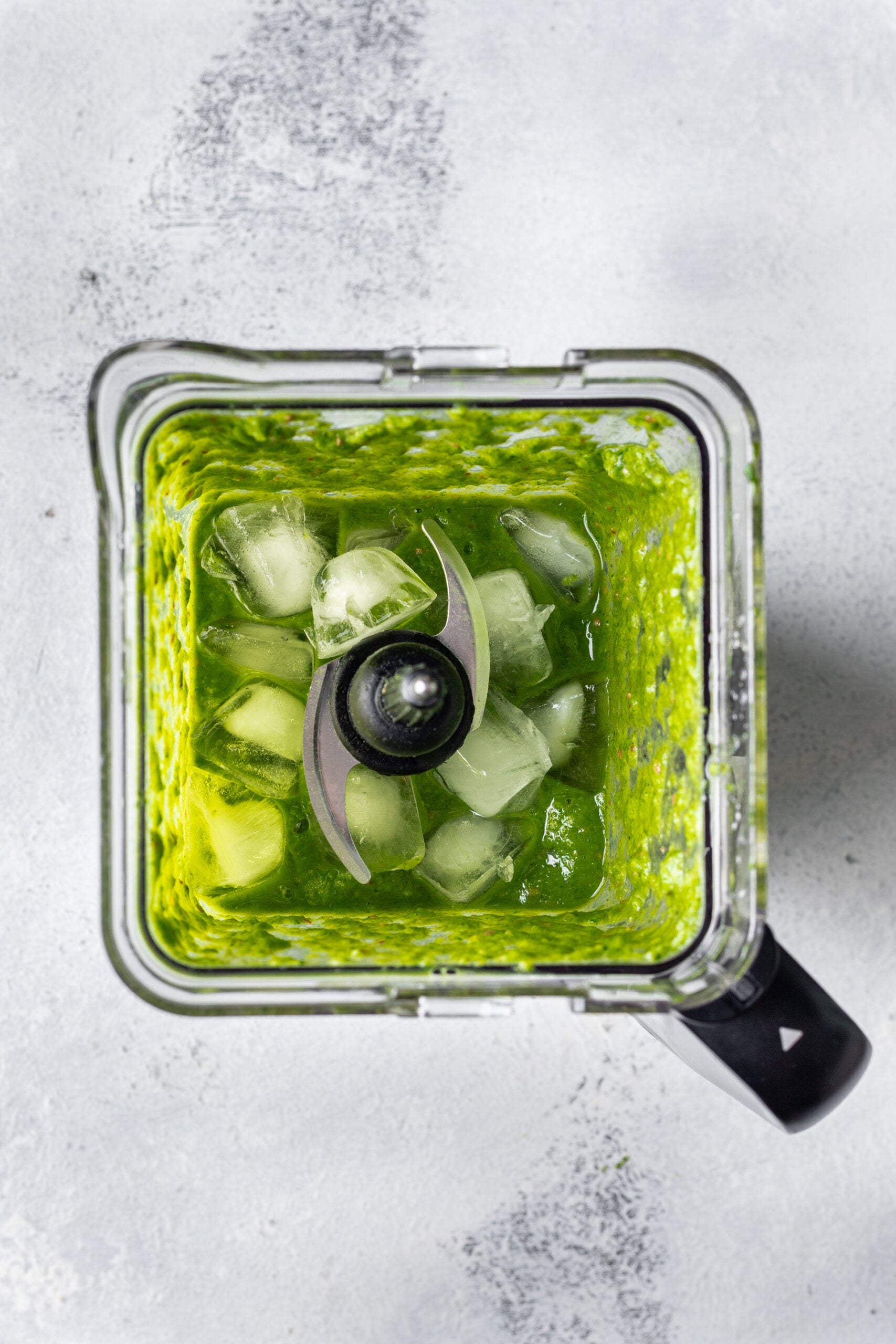 green smoothie in a blender with ice