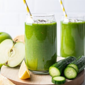 green smoothie in a glass with a yellow straw