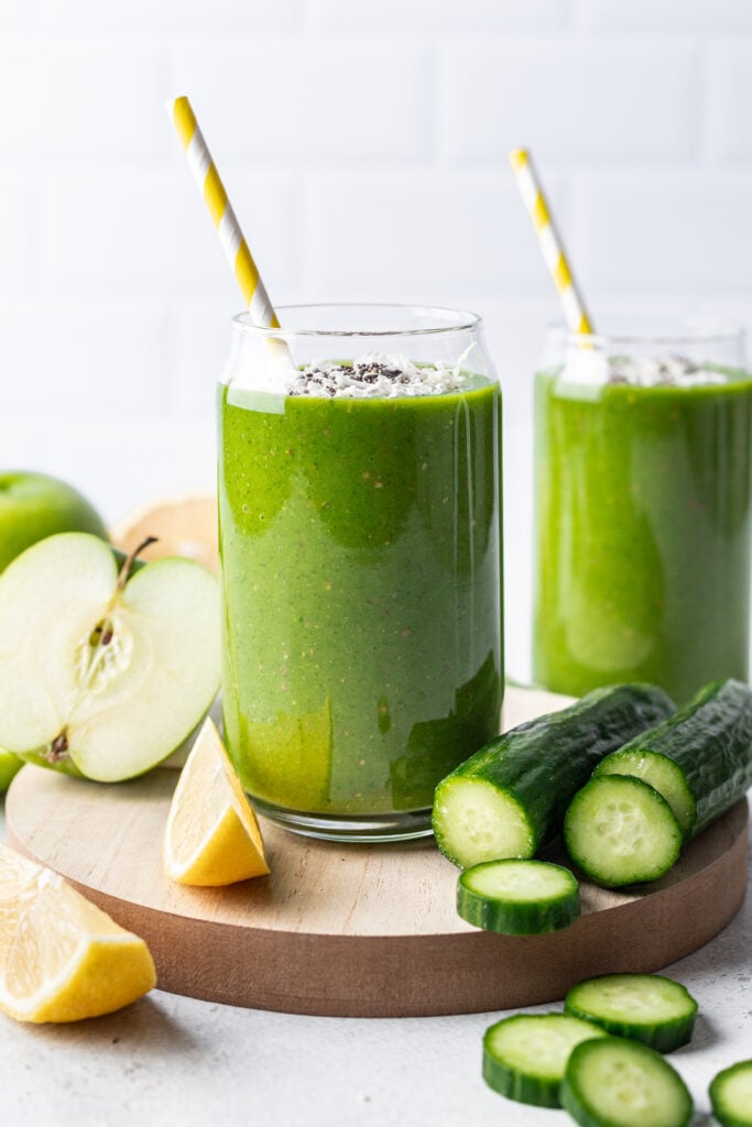 green smoothie in a glass with a yellow straw