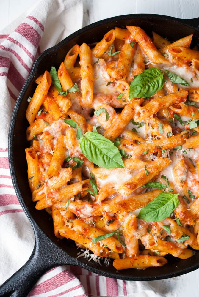 a skillet with baked pasta with melted cheese