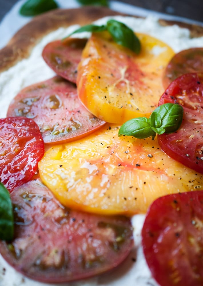 close up of sliced tomatoes on a pizza