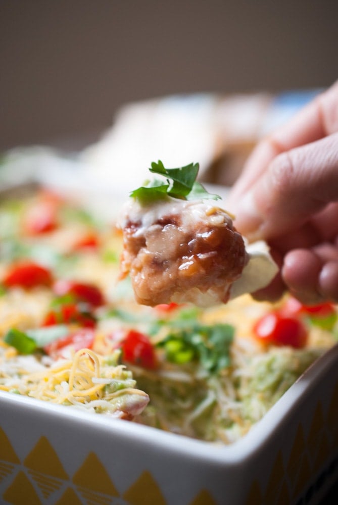 Taco Dip on a chip with a hand holding it