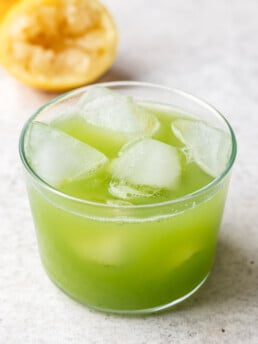 green juice in a glass with ice