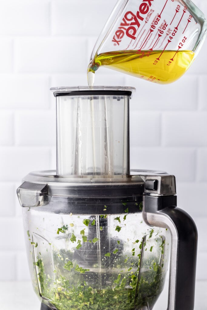 oil being poured into a food processor