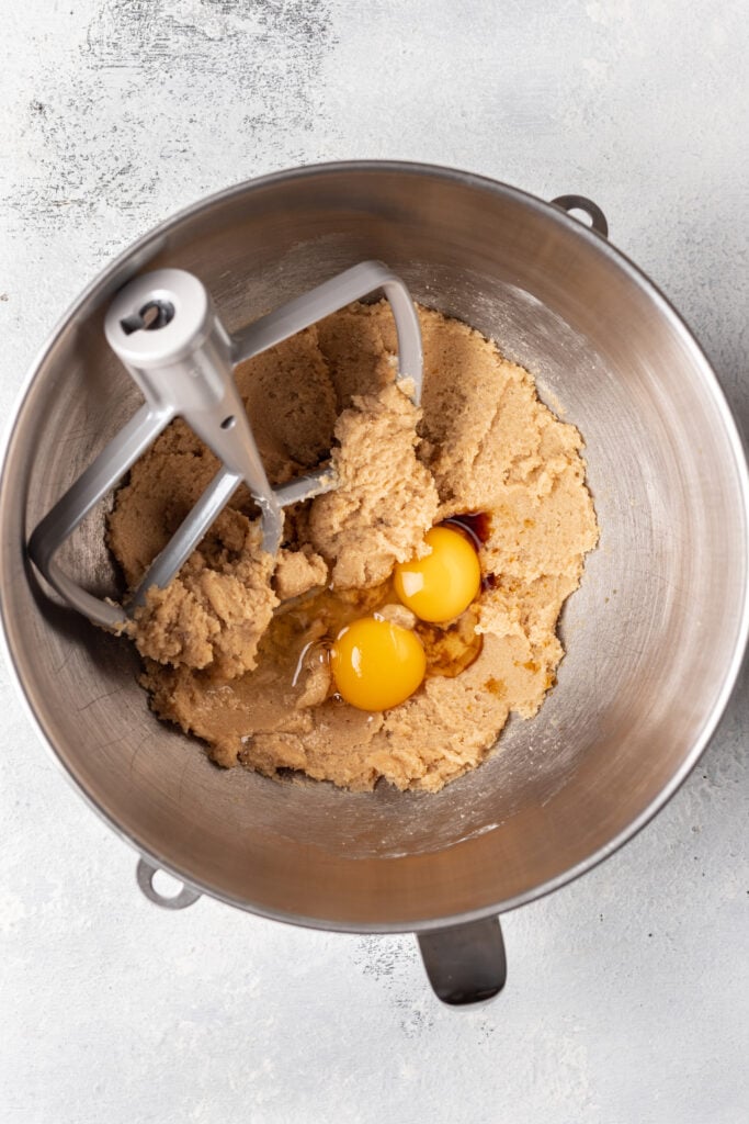 cookie dough ingredients in a bowl with 2 cracked eggs