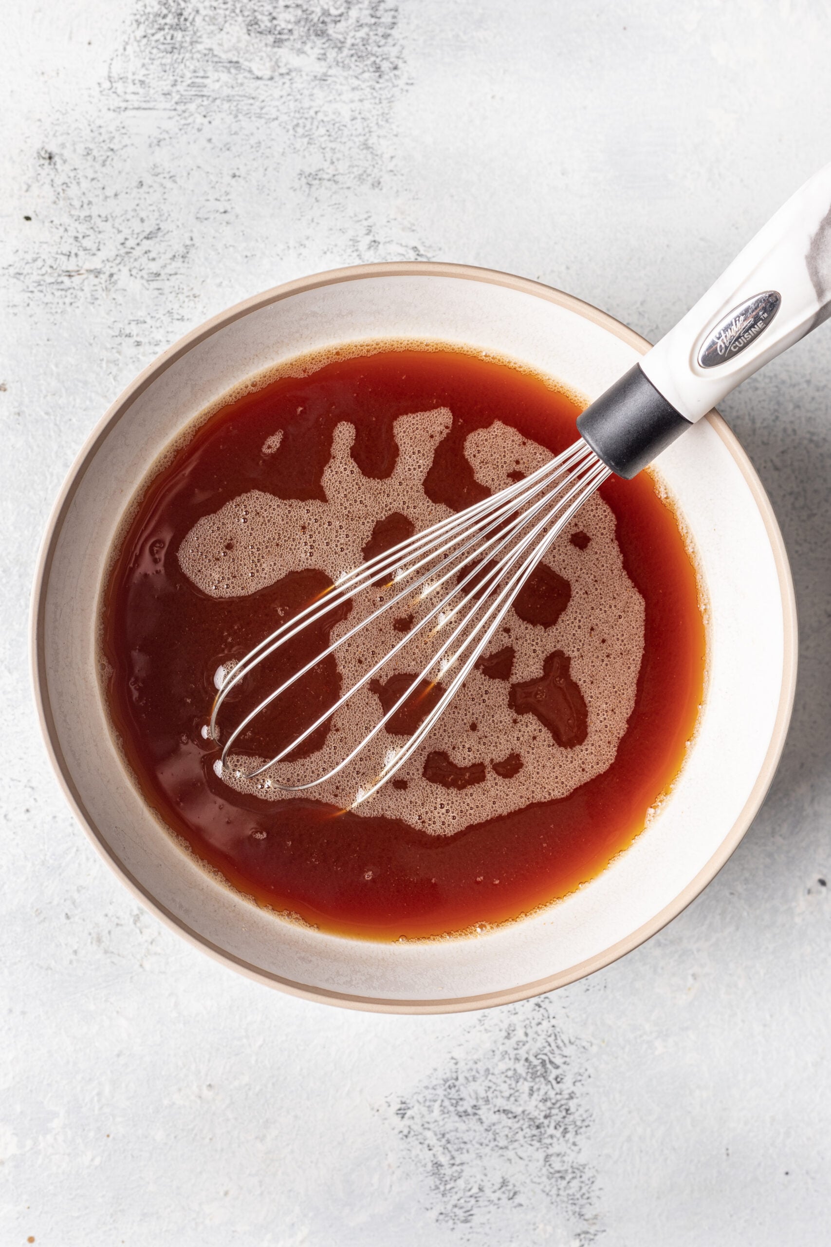 broth in a bowl with a whisk