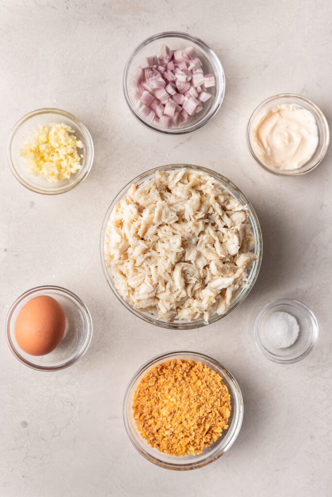 ingredients in bowls like fresh crab, shallot, garlic, egg and corn flake crumbs