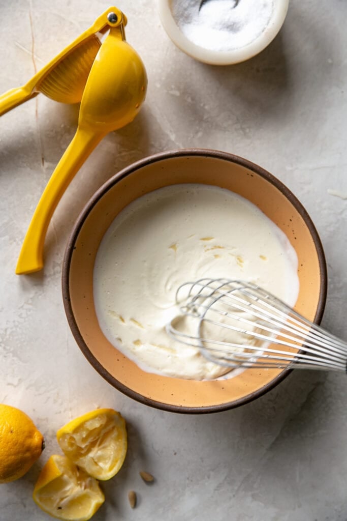 Whisk in Bowl with Lemons and Mayonnaise Making Crab Cake Dip