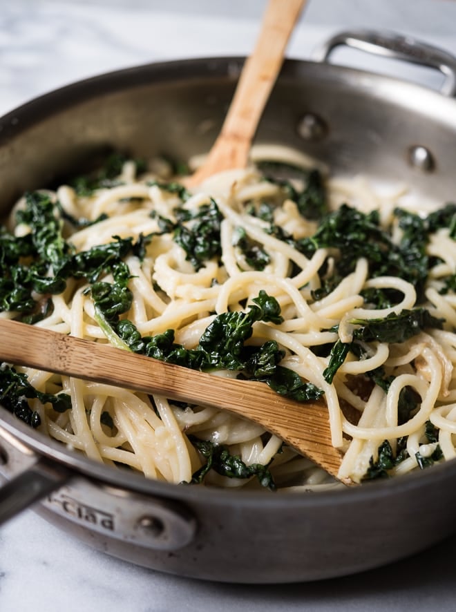 Lemony Pasta with Kale and Parmesan in a pan with a wooden spoon
