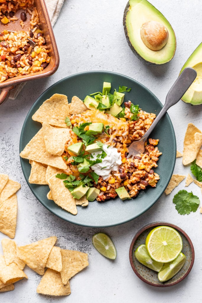 taco casserole scooped onto a plate with chips on the side