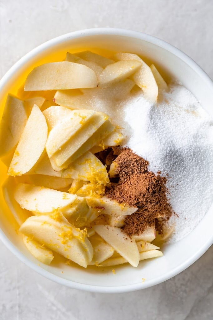 Apples, sugar, and lemon zest in a mixing bowl