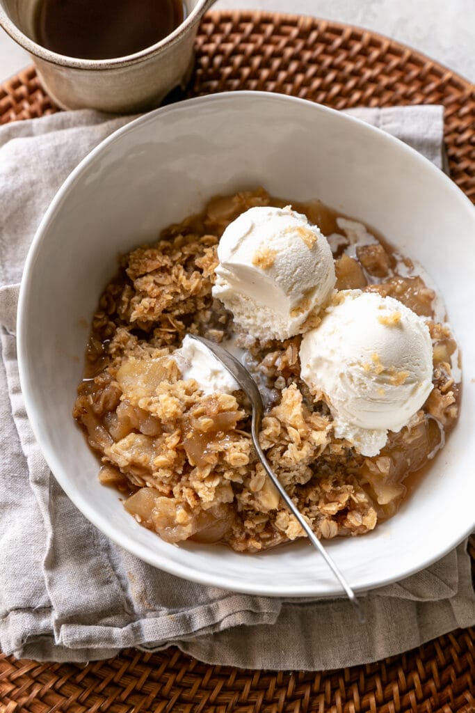 Close Up of Apple Crisp in White Bowl with Ice Cream