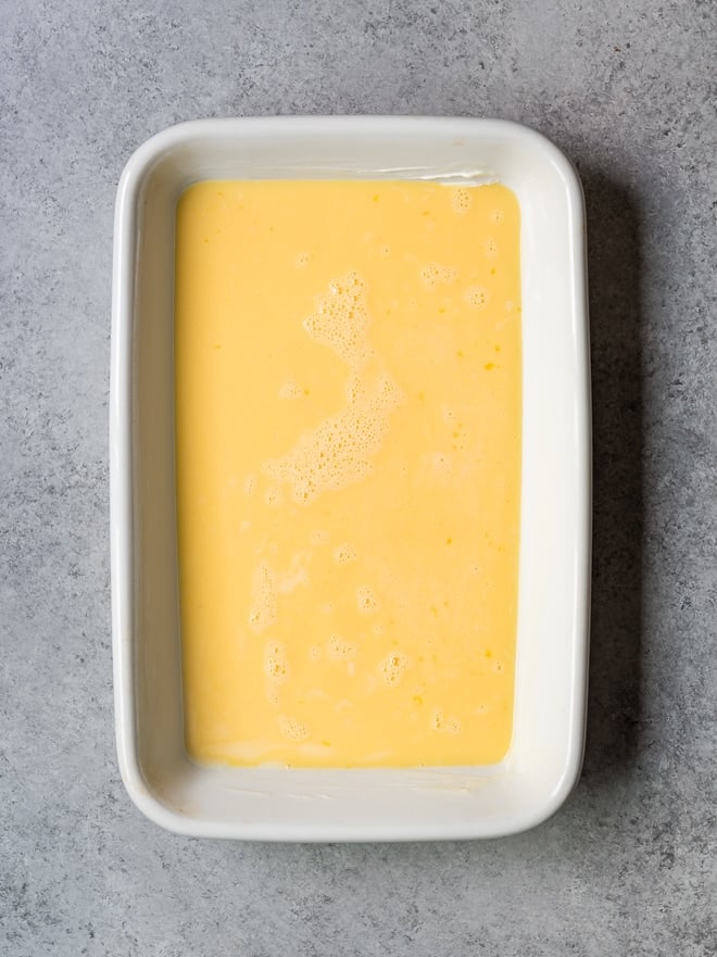 beaten eggs in a large white baking dish