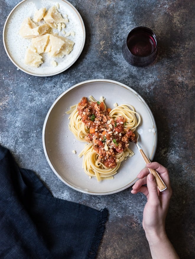 turkey bolognese served over fettucine on a plate with a fork