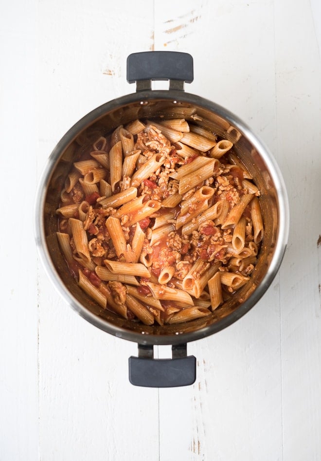 pasta and ground turkey in an instant pot with tomato sauce mixed in