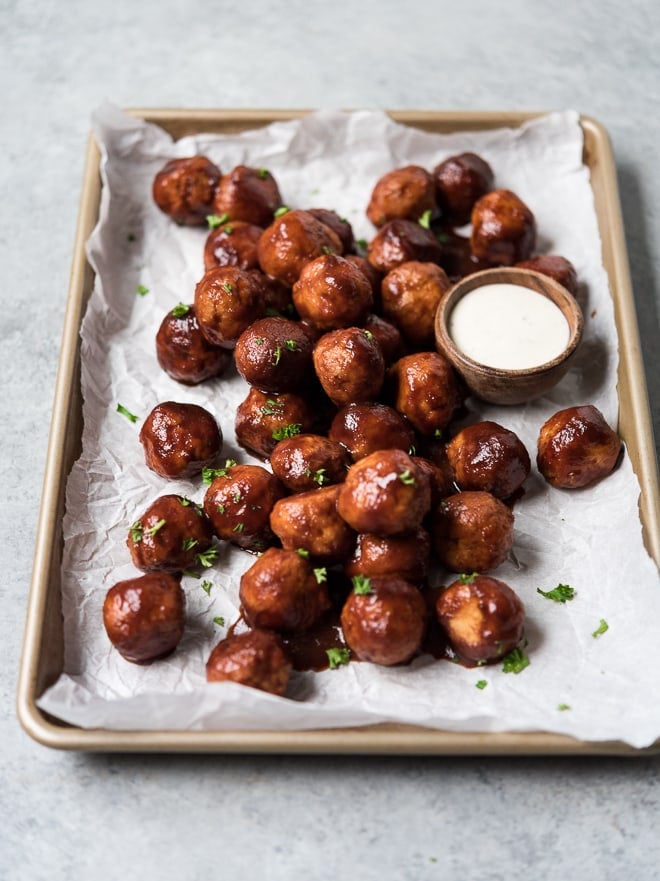 shot of meatballs on a sheet pan with dipping sauce