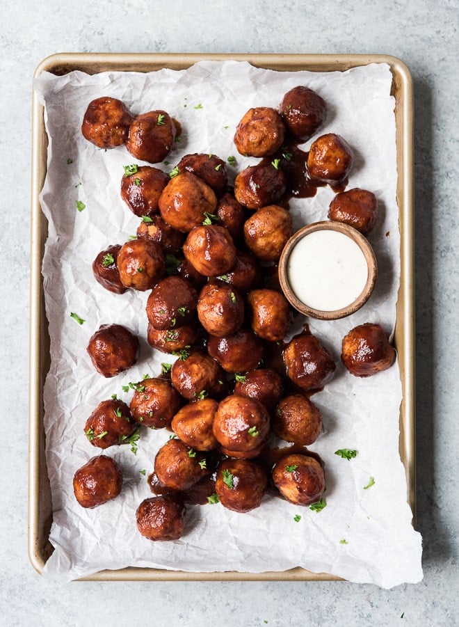 shot of meatballs on a sheet pan with dipping sauce