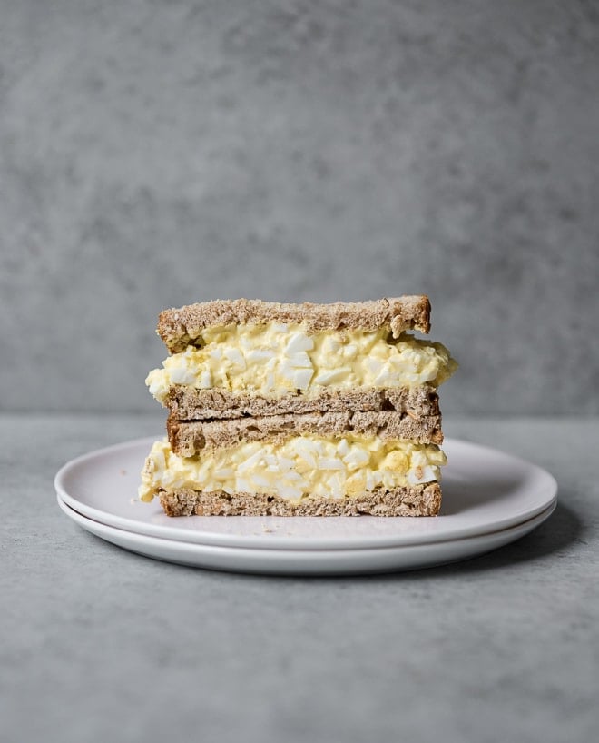 egg salad sandwich stacked on a plate