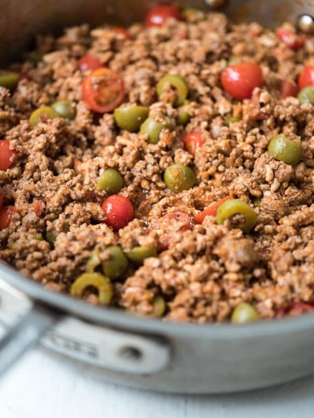 ground meet in a pan with olives and tomatoes