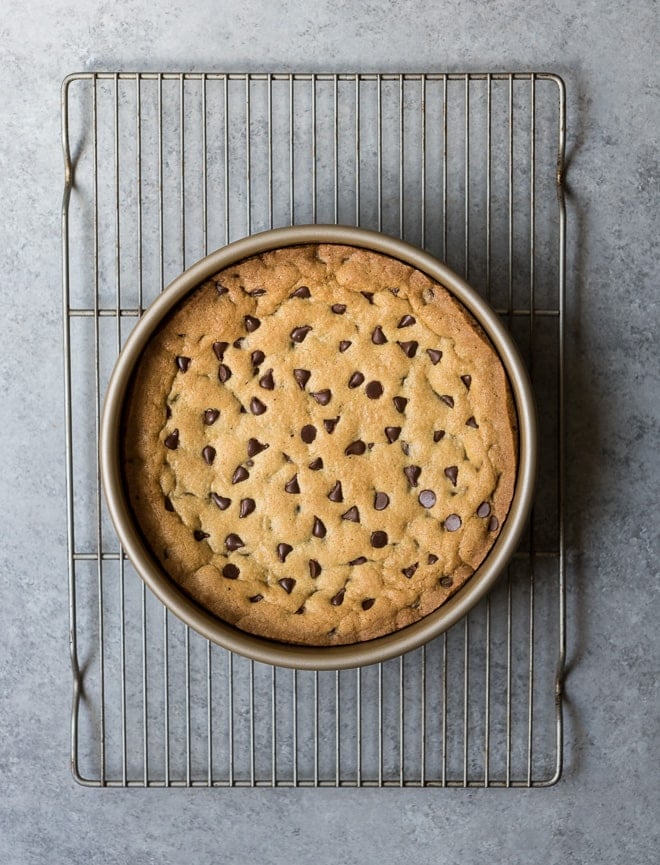 Chocolate Chip Cookie Cake in a 9 inch round cake pan sitting on a cooling rack