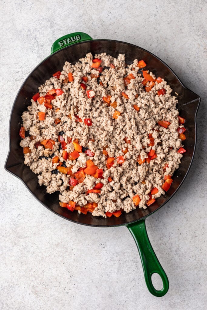 cast iron skillet with chopped bell peppers and ground turkey