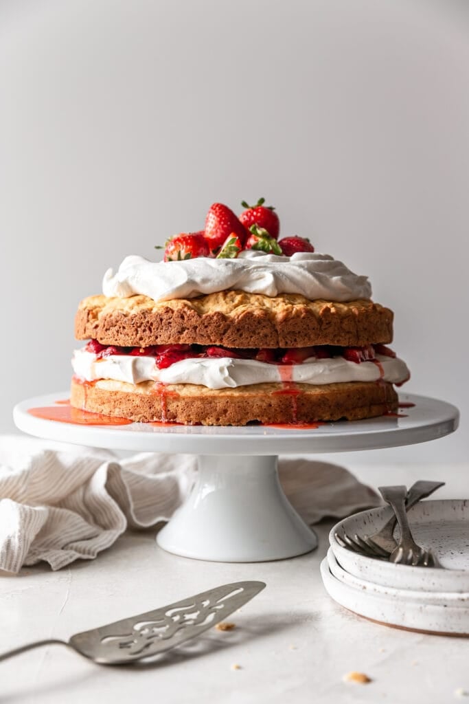 straight on shot of classic strawberry shortcake on a white cake stand