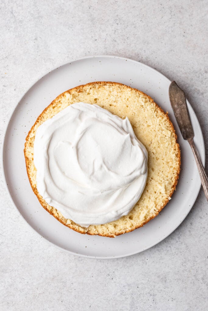 whipped cream spread partially onto cake