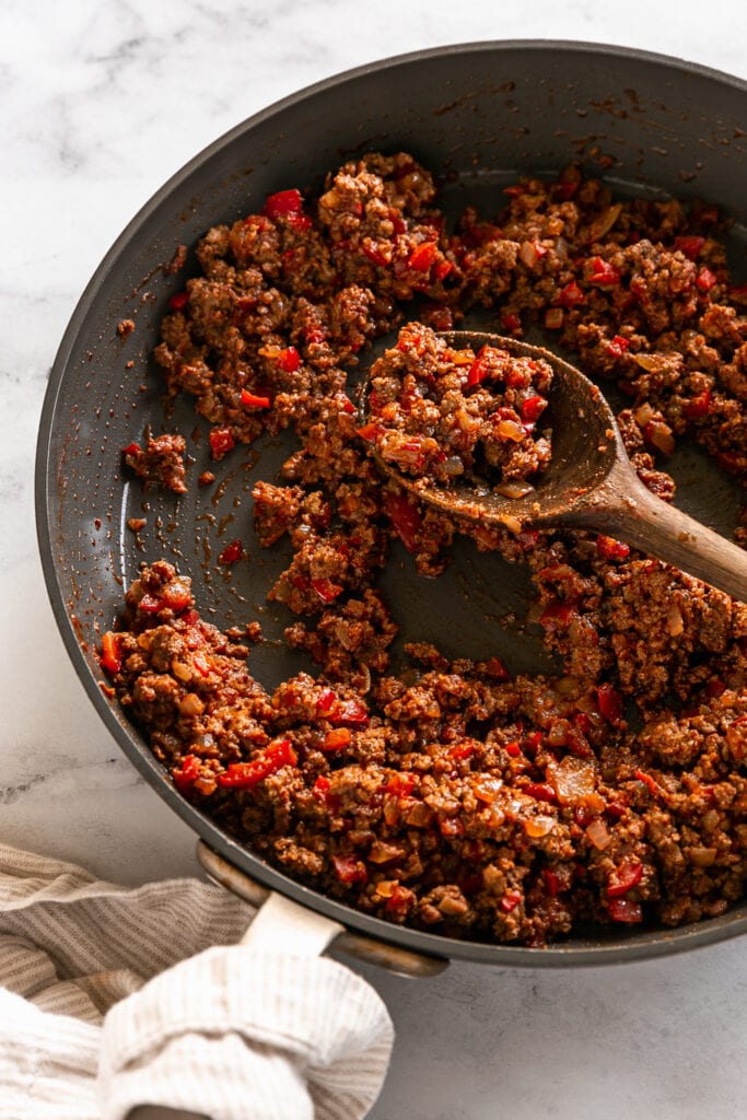 pan with ground meat and a wooden spoon