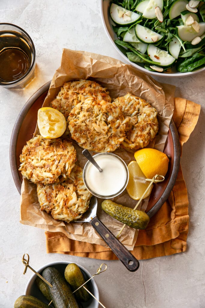 Platter of Crab Cakes with Fresh Lemon, Pickles, and Mayo Sauce