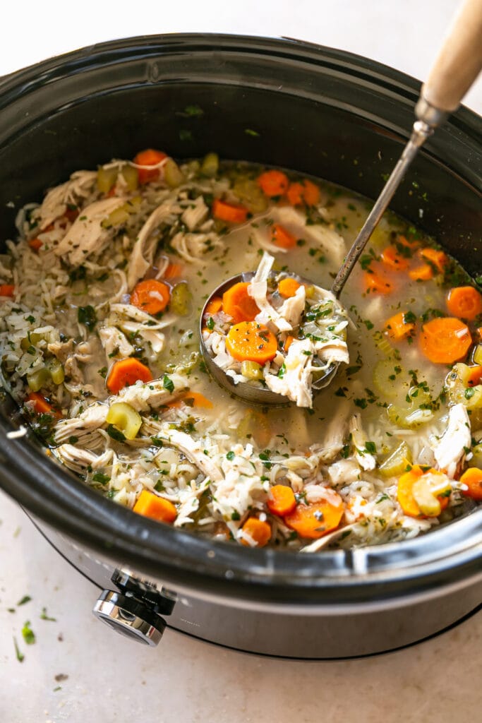 Slow Cooker with Chicken and Rice Soup and a Ladle