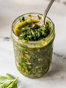 Close up of Chimichurri in glass jar with a spoon