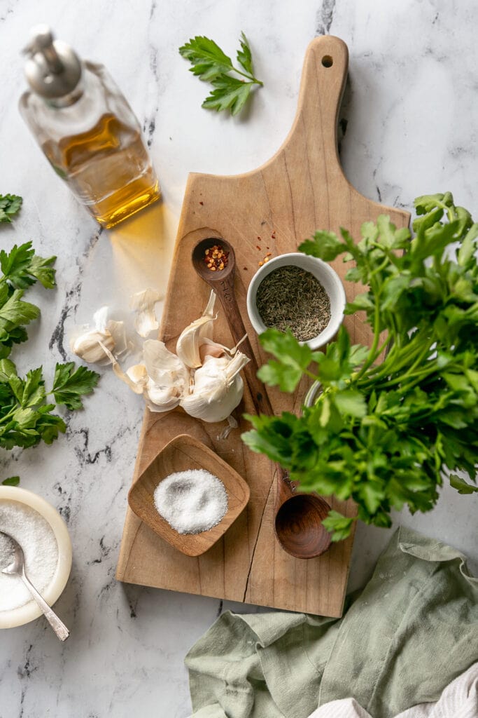 7-Ingredient Chimichurri - parsley, spices, garlic and olive oil on cutting board
