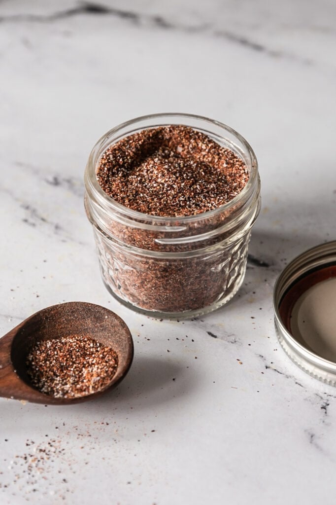 Taco seasoning spices in a glass jar on a marble countertop