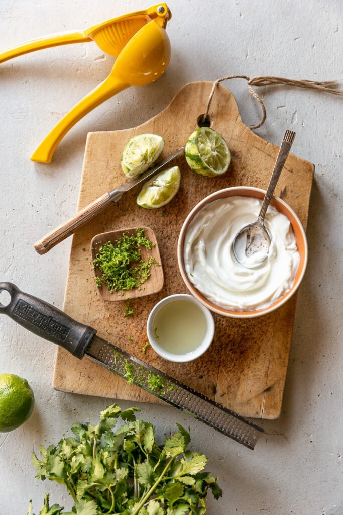 Easy 4-Ingredient Lime Crema - yogurt, lime juice and zest, knife, limes on cutting board