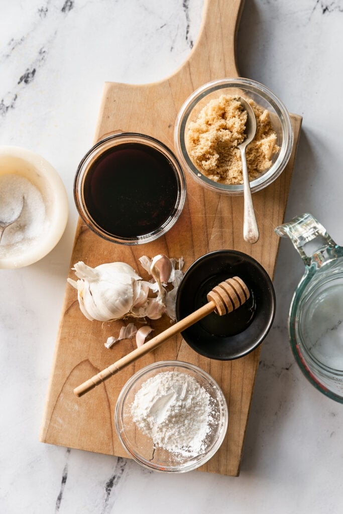 LIBAD Easy Homemade Teriyaki Sauce - soy sauce, honey, garlic, brown sugar and corn starch on a wood cutting board on marble counterop