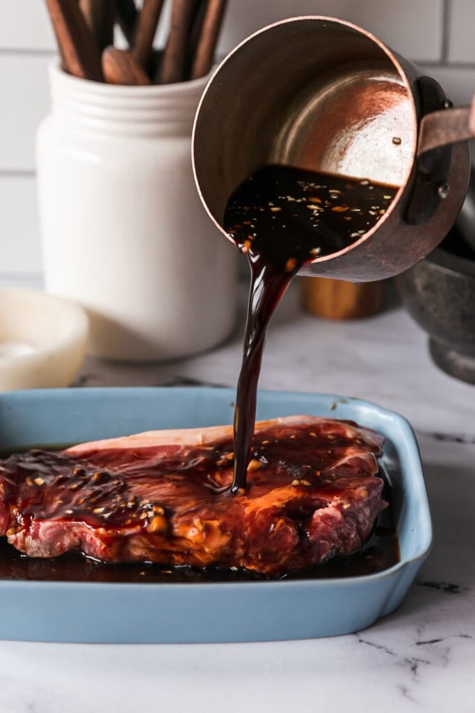 The Best Balsamic Steak Marinade - pouring marinade onto steak