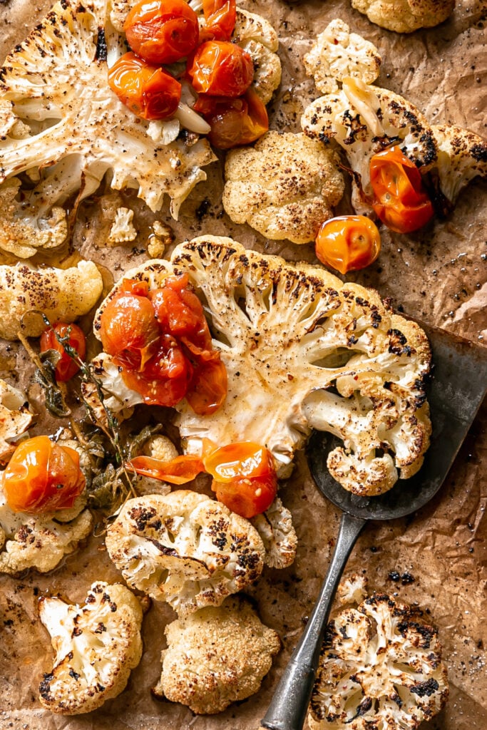 Cauliflower Steaks with Tomato Garlic Confit - roasted cauliflower steaks on sheet pan with tomato confit and spatula