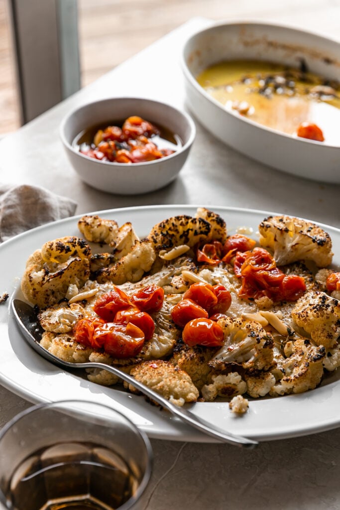 Cauliflower Steaks with Tomato Garlic Confit - roasted cauliflower steaks on white platter with tomato confit