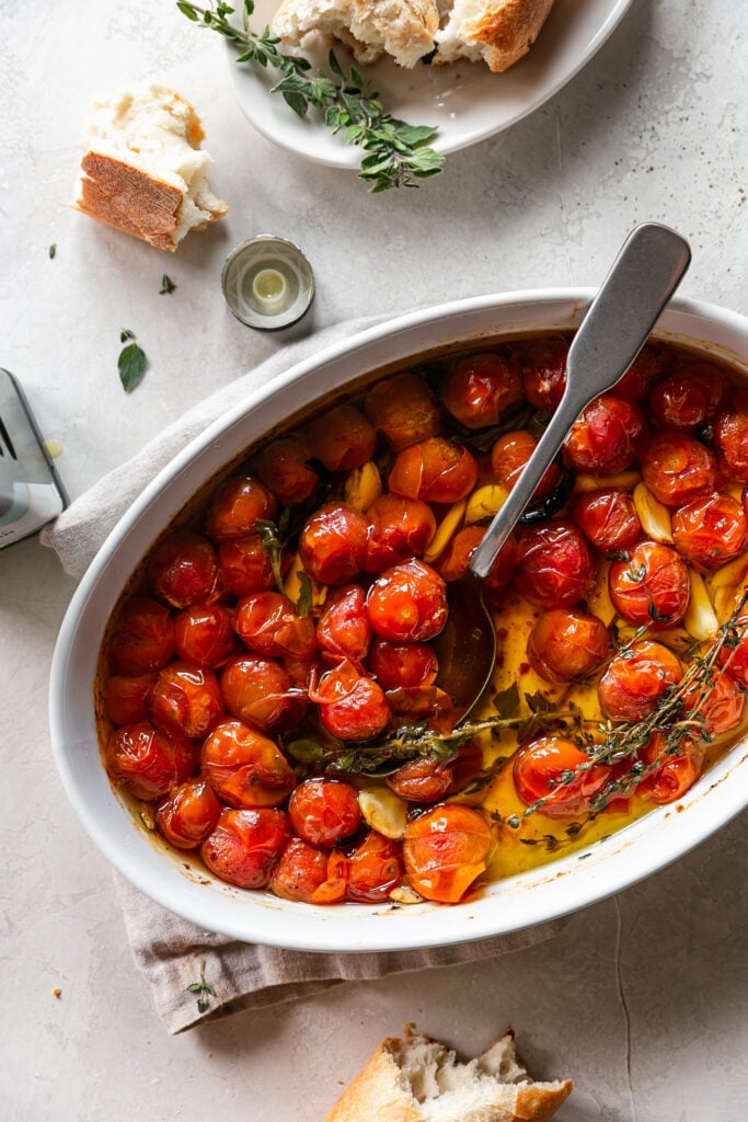 Quick Tomato and Garlic Confit - Roasted Cherry Tomatoes, Herbs and Garlic with Spoon and Torn Bread