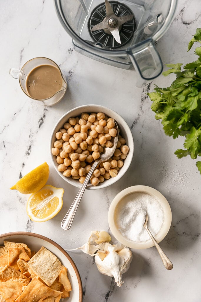 Best 5-Minute Blender Hummus - chickpeas, lemon, tahini, garlic and blender on countertop